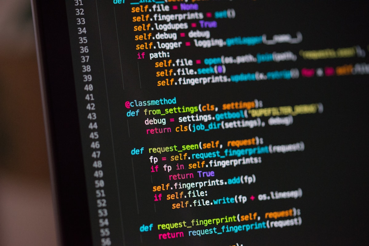 Software developer working with programming code on a laptop