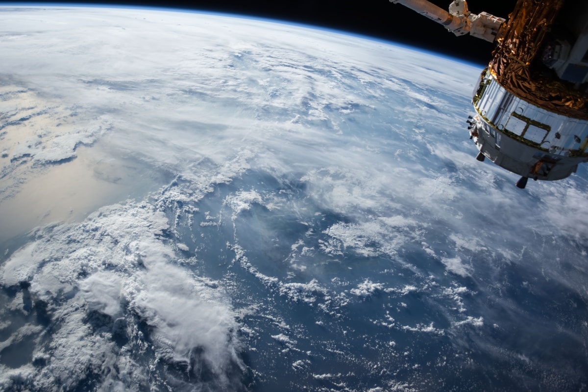 Astronaut floating outside a spacecraft above Earth